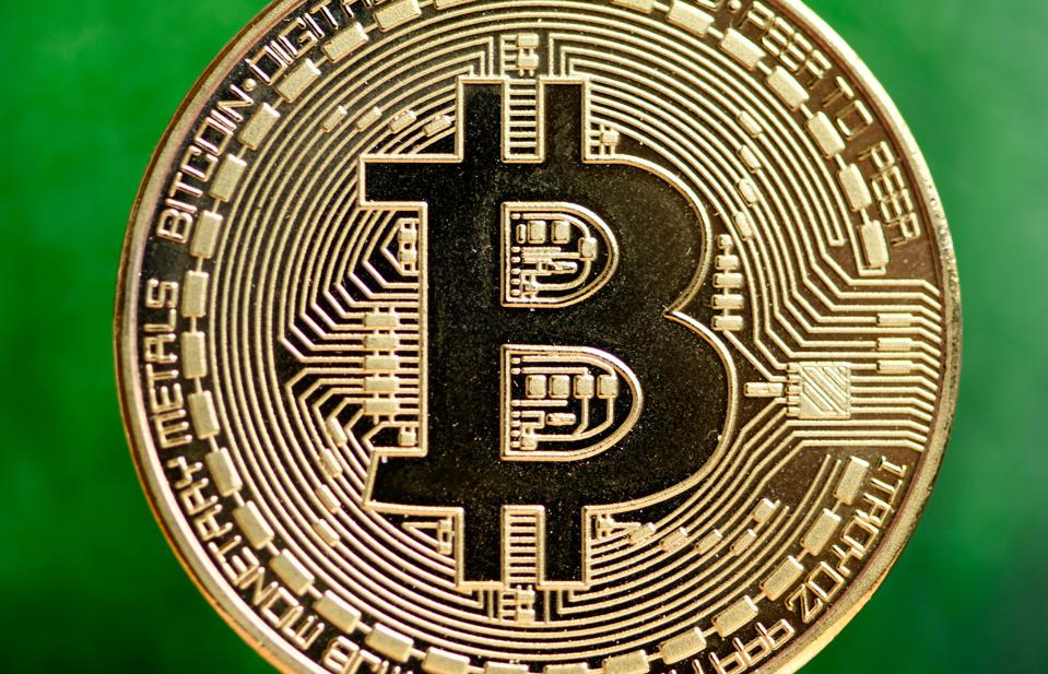 A picture of bitcoin, a digital currency, against a green background. 