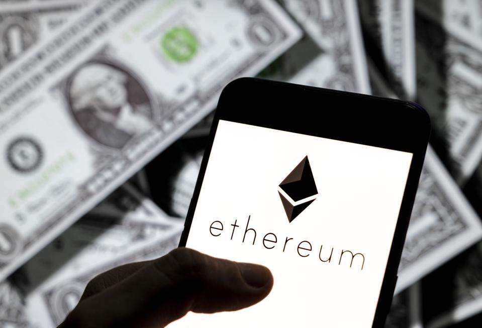 In this photo illustration, cryptocurrency ether, is displayed along with some dollars. 